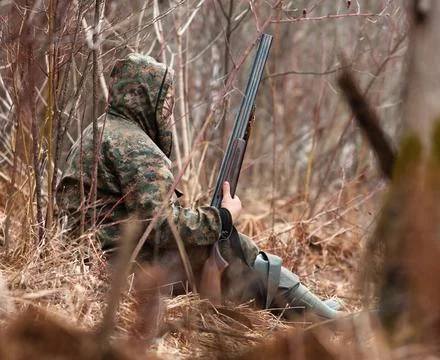 Hunter hidden in shrubs Stock Photos