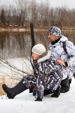 Hunter with his son on the river Stock Photos