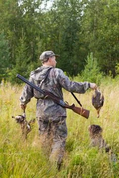 The hunter holds in his hands two downed grouses Stock Photos