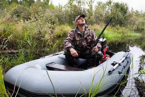 The hunter in inflatable boat Stock Photos