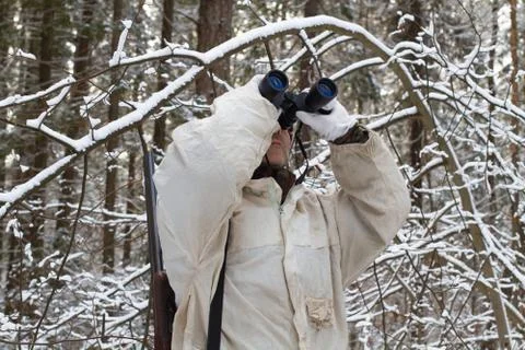 Hunter look through binoculars in the winter forest Stock Photos