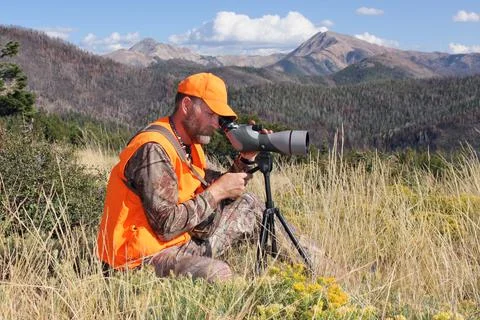 Hunter looking through spotting scope Stock Photos