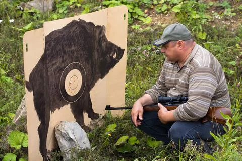 Hunter looking at traces from shots on target Stock Photos