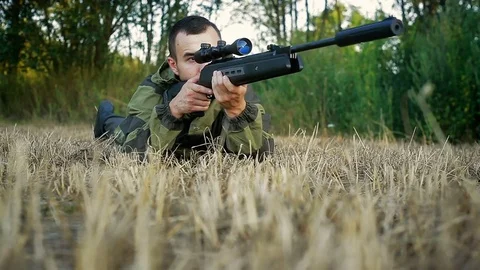 Hunter is lying in a field and prepare to shoot 動画素材 80492330