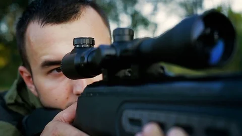 Hunter is lying in a field and prepare to shoot Stock Footage 80516647