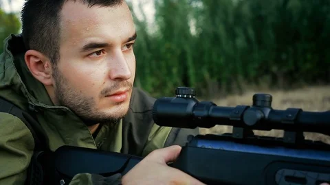 Hunter is lying in a field and prepare to shoot Vídeo Stock 90778439