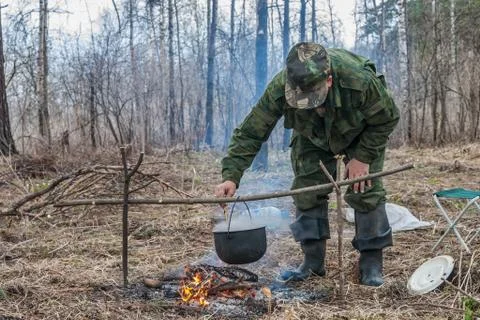The hunter makes a dinner on a bonfire 스톡 사진