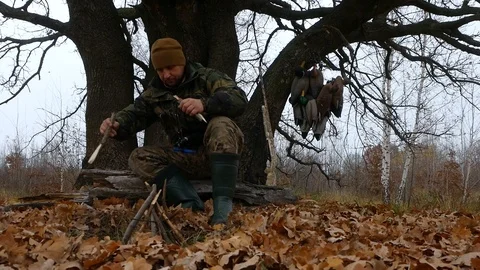Hunter makes a fire at a rest camp Stock Footage 100631072