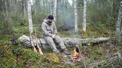 Hunter man at a fire in the forest Stock Footage 70777991