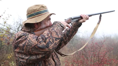 Hunter man with gray beard in hunter suit load cartridges in a double-barreled r Video stock 164292891
