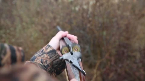 Hunter man with gray beard in hunter suit load cartridges in a double-barreled r Video stock 164293427