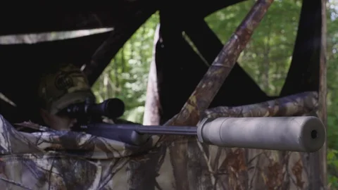 Hunter or Sniper taking  aim from a camouflage blind. Stock Footage 88165228