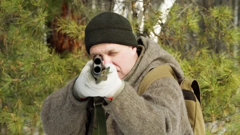 The hunter points the barrel of the gun directly at the camera. Stock Footage 303775404