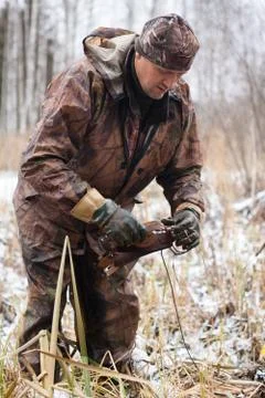 Hunter preparing leghold trap for setting Stock Photos