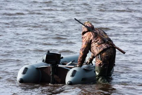 Hunter pulls the boat from shallow water Stock Photos