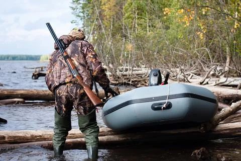 The hunter pulls the boat on the water Stock Photos