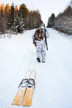 The hunter pulls the skis on the road Stock Photos