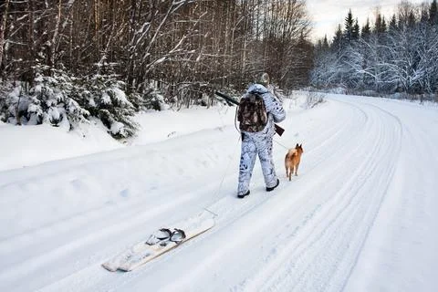 The hunter pulls the skis on winter road Stock Photos
