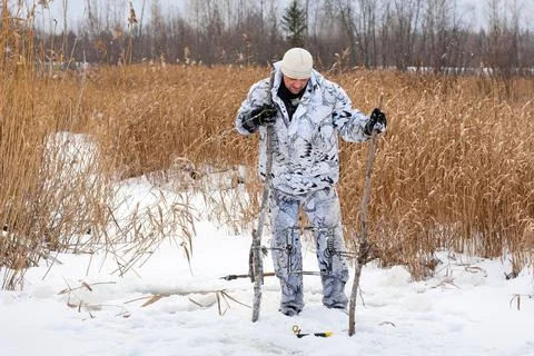 Hunter putting a trap for beaver Stock Photos