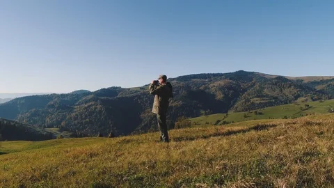 The hunter raised his binoculars, looking for his next destination in the Stock Footage 126516494