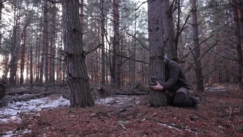 A hunter sets a photo trap on a tree, hobby Stock Footage 201109985