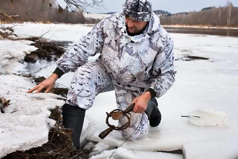 Hunter setting a leghold trap for beaver Stock Photos