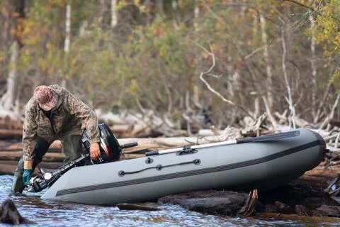 Hunter setting the motor on the boat Stock Photos