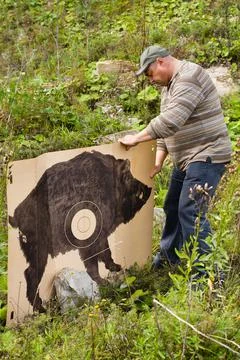 Hunter setting the target for shooting Stock Photos