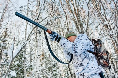 Hunter shooting in the forest in winter Stock Photos