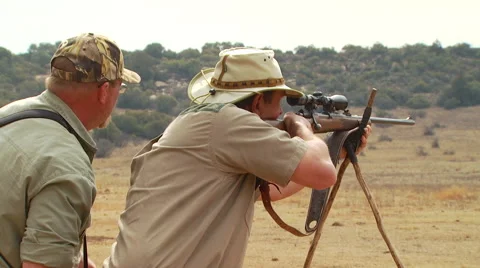 Hunter shooting wildebeest at ranch Stock Footage 54591100