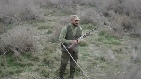 A hunter with a shotgun makes a comment Stock Footage 270254368