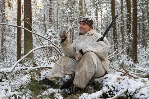 A hunter sits with a cup of tea in the winter forest Stock Photos