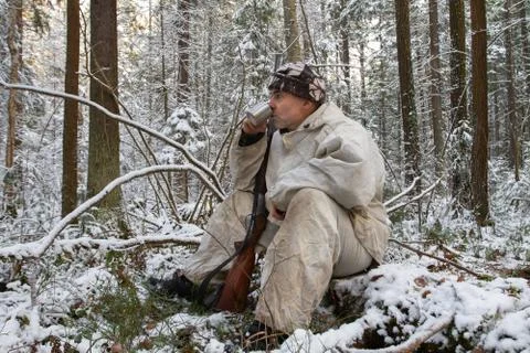 Hunter sitting and drinking tea in the winter forest Stock Photos