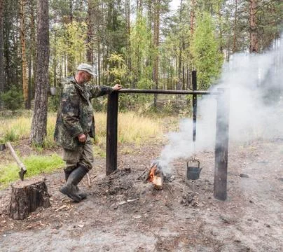 Hunter standing at bonfire Stock Photos