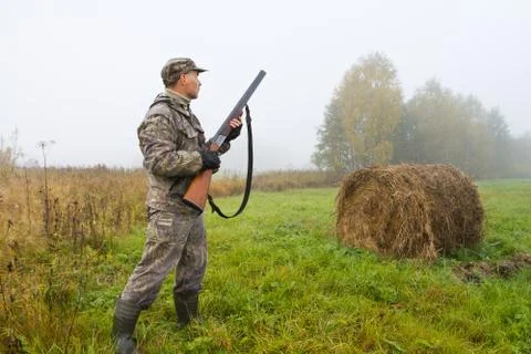 The hunter stands on the mowing ready to shoot Stock Photos