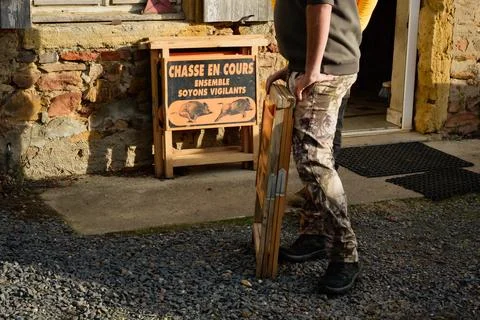 A hunter takes down the signs warning of ongoing hunting Stock Photos