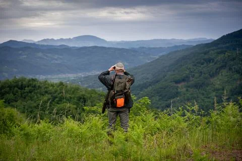 Hunter using binoculars too look for wildlife in the distance Stock Photos
