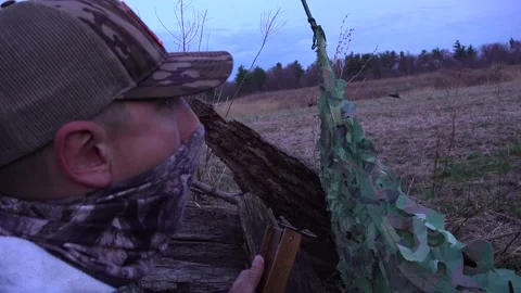 Hunter Using Turkey Box Call with Camera Pan Across a Spring Field Stock Footage 345165553