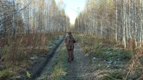 The hunter is walking along the road in the forest Stock Footage 220169768