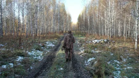 The hunter is walking along the road in the forest Stock Footage 220169811