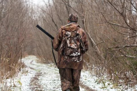 Hunter walking on the forest road in winter Stock Photos