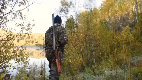 The hunter walks by the lake Stock Footage 95462369