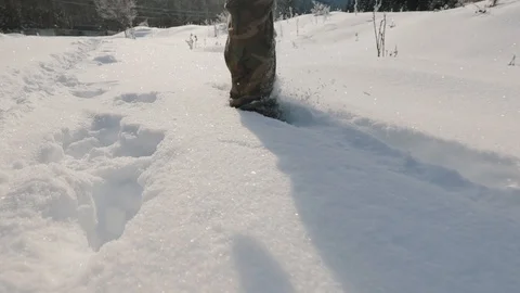 Hunter walks through snow-capped mountains Stock Footage 123277139