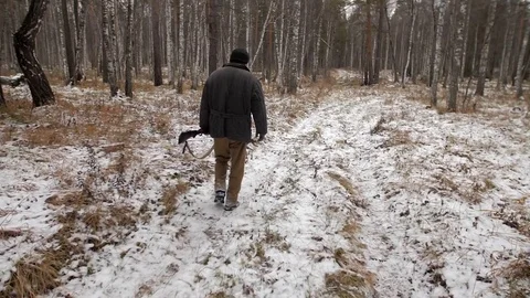 Hunter walks through a snow forest with a gun Stock Footage 81769560