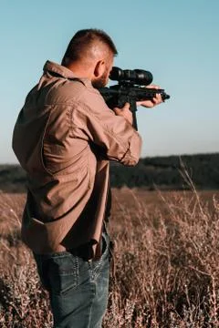A hunter with a weapon on the hunt against the backdrop of a beautiful summer Stock Photos