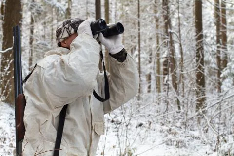 Hunter in winter forest with binoculars Stock Photos