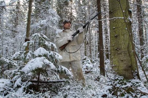 Hunter in the winter twilight forest Stock Photos