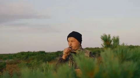 Hunters hide behind a cedar bush are called ducks, geese Stock Footage 117398143
