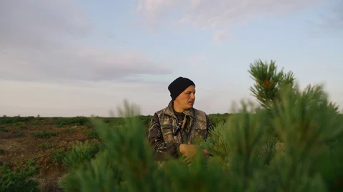 Hunters hide behind a cedar bush are called ducks, geese Stock Footage 117398437