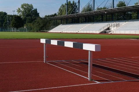Hurdle on a red athletic track at a training facility during daylight Stock Photos
